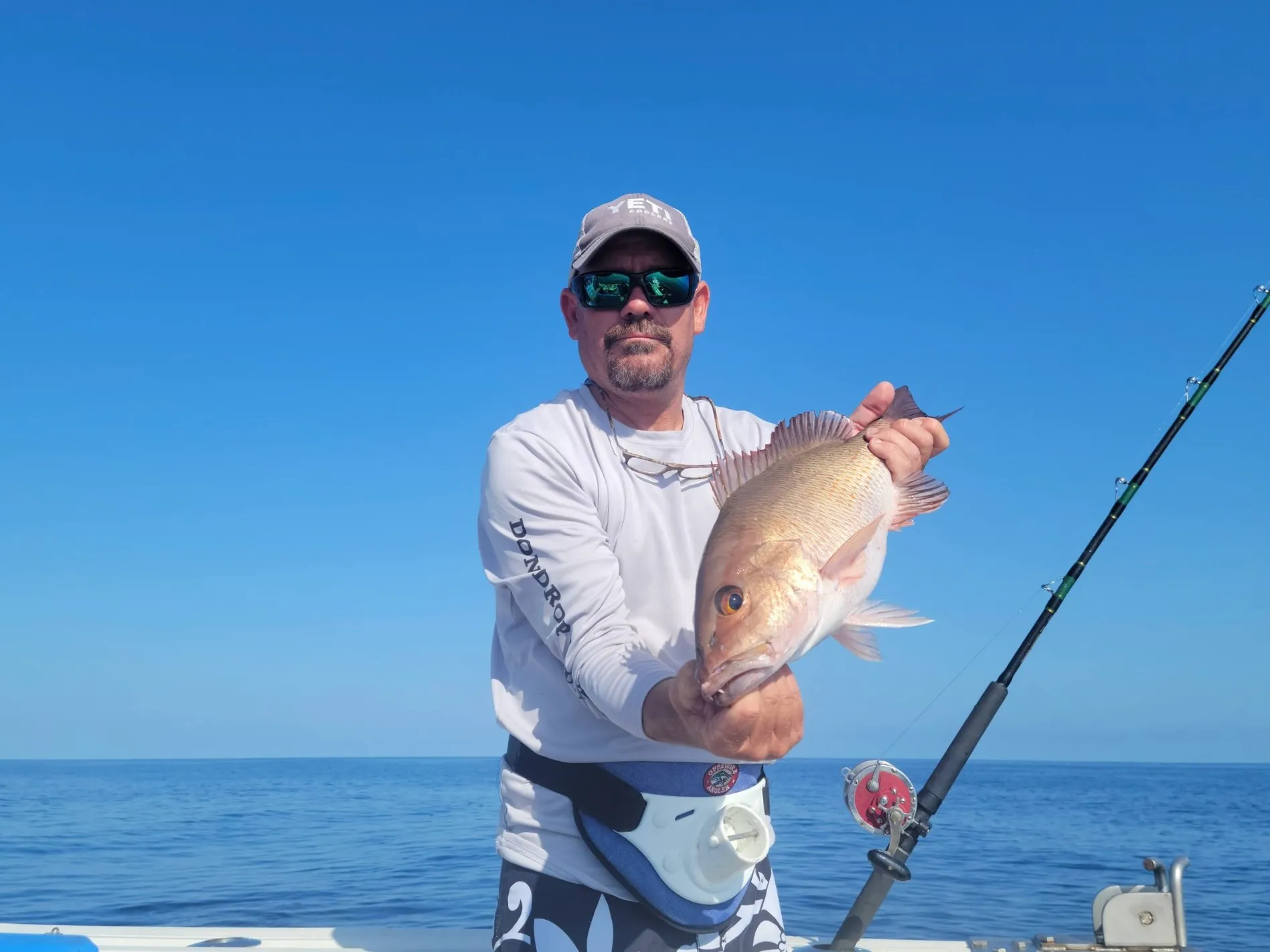 Captain Cuda holding a red snapper catch aboard Phat Kat on a Gulf fishing charter from St. Petersburg
