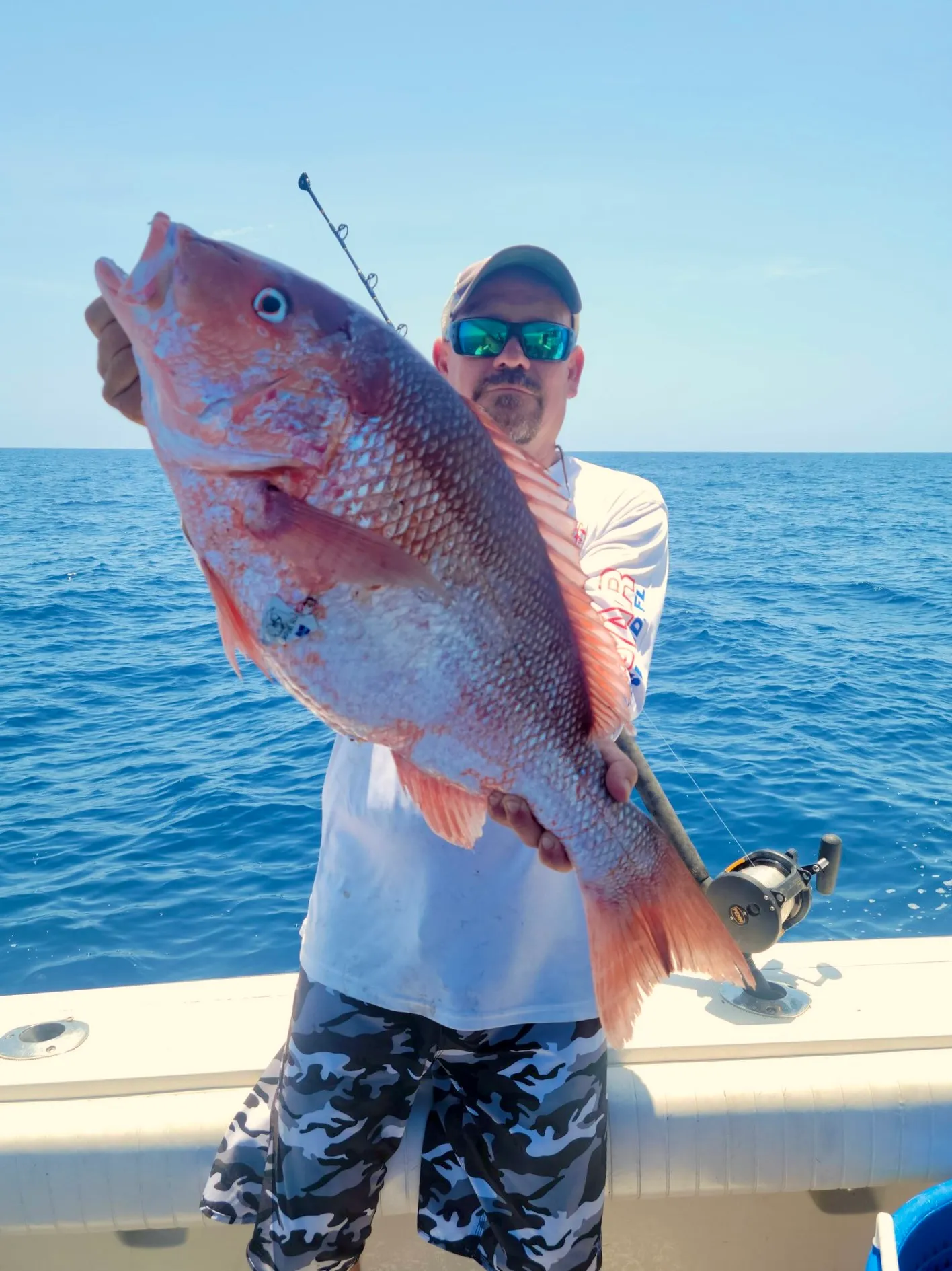 Captain Cuda holding a snapper offshore in the Gulf of Mexico aboard Phat Kat