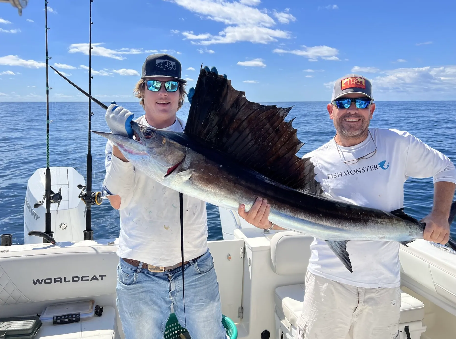 Crew holding a grouper aboard Phat Kat in the Gulf of Mexico