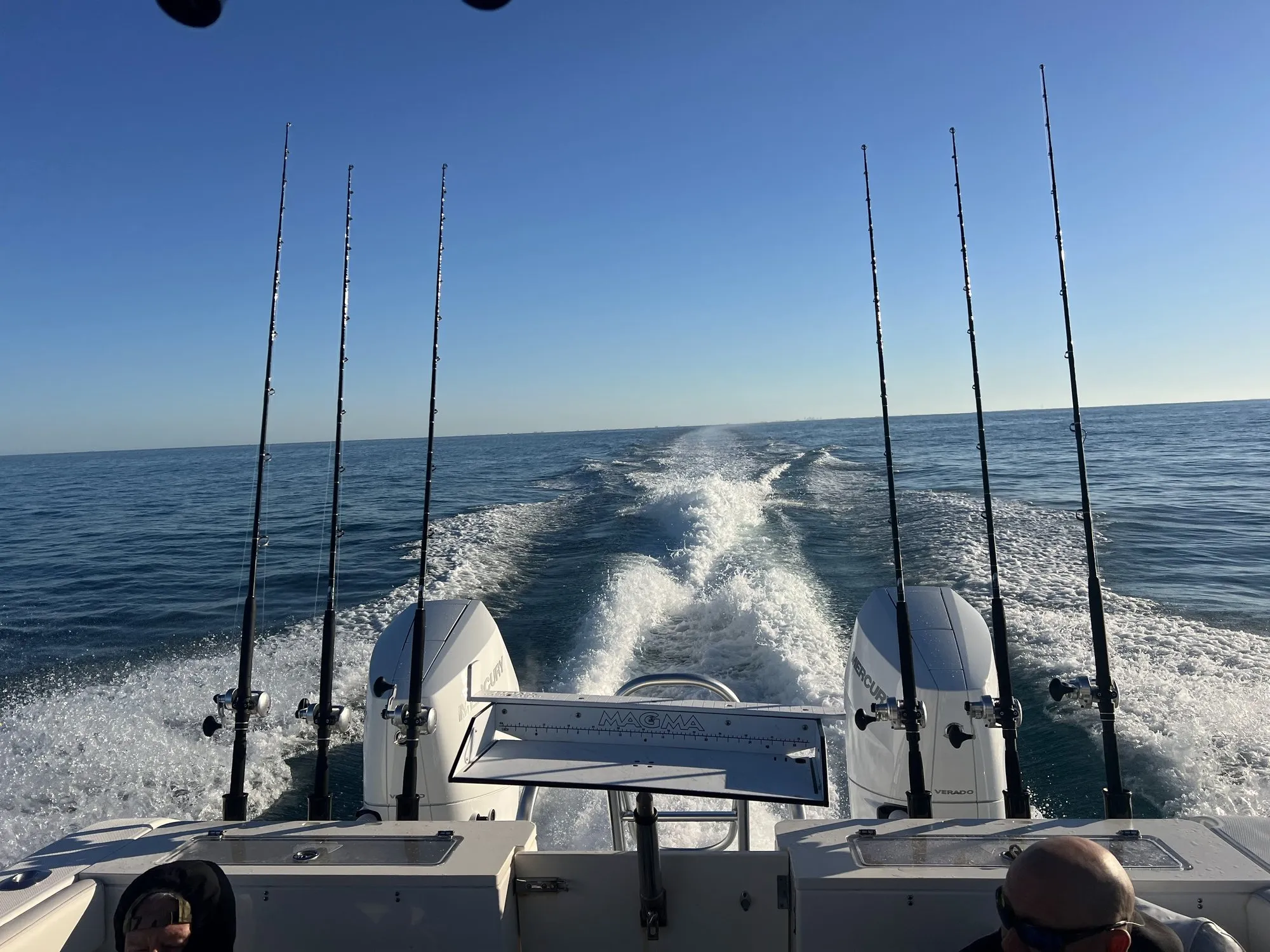 Phat Kat running across the open Gulf with fishing rods lined up across the stern