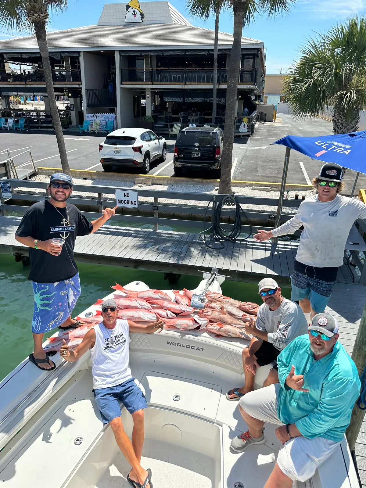 Charter guests with a large pile of red snapper on the bow of Phat Kat at the marina dock in St. Petersburg