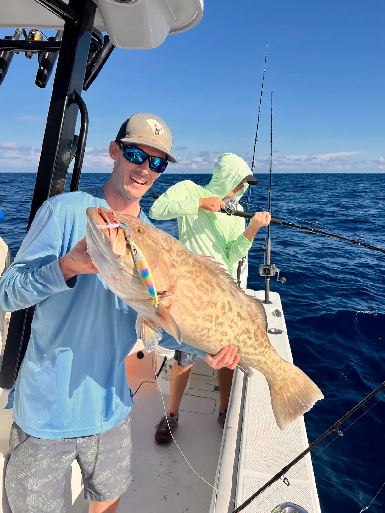 Guest holding a grouper in the Gulf of Mexico aboard Phat Kat