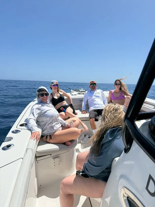 Guests relaxing on the bow of Phat Kat under a clear blue sky
