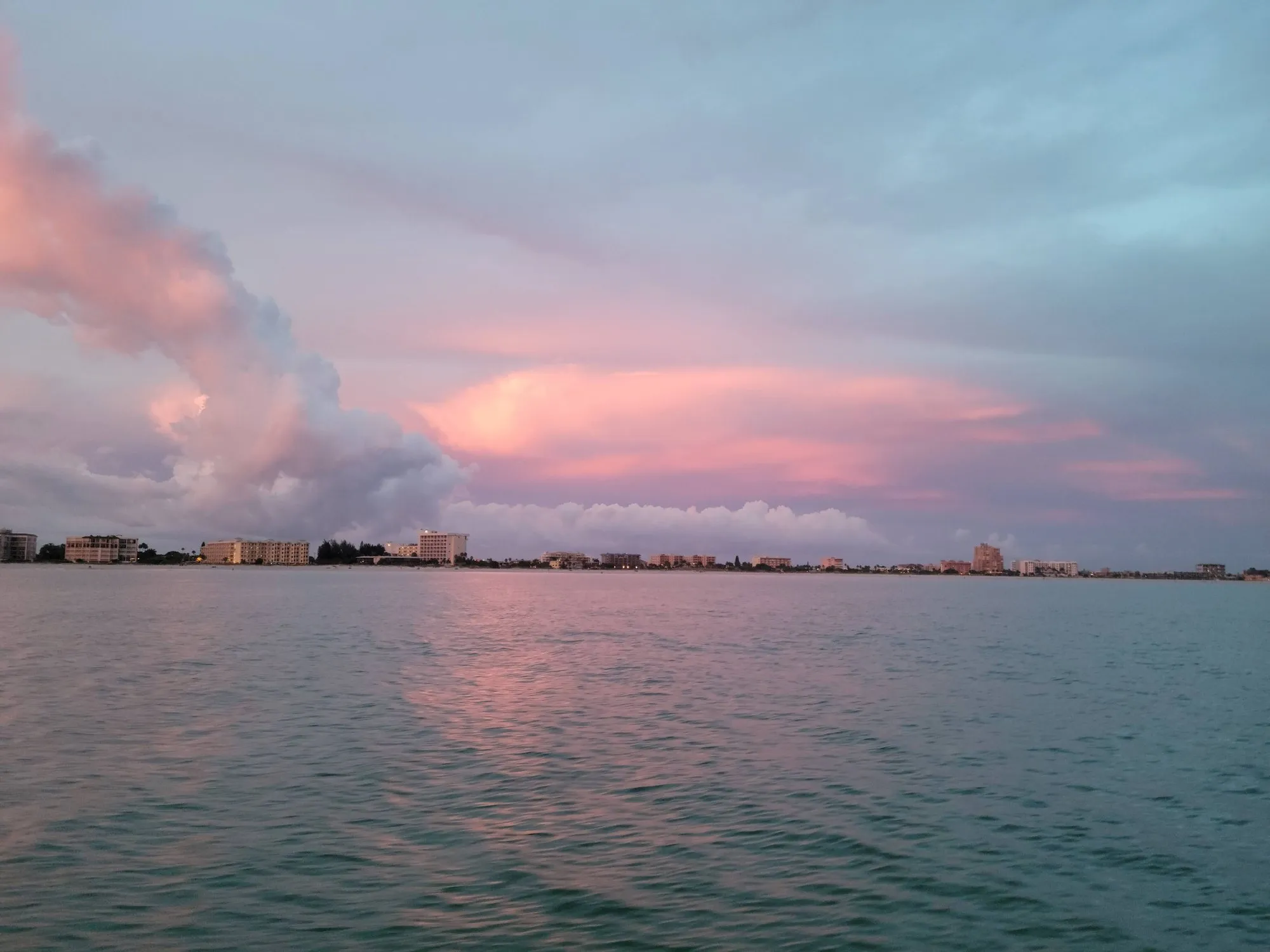Pink sunset clouds over the St. Pete waterfront, reflected in calm water