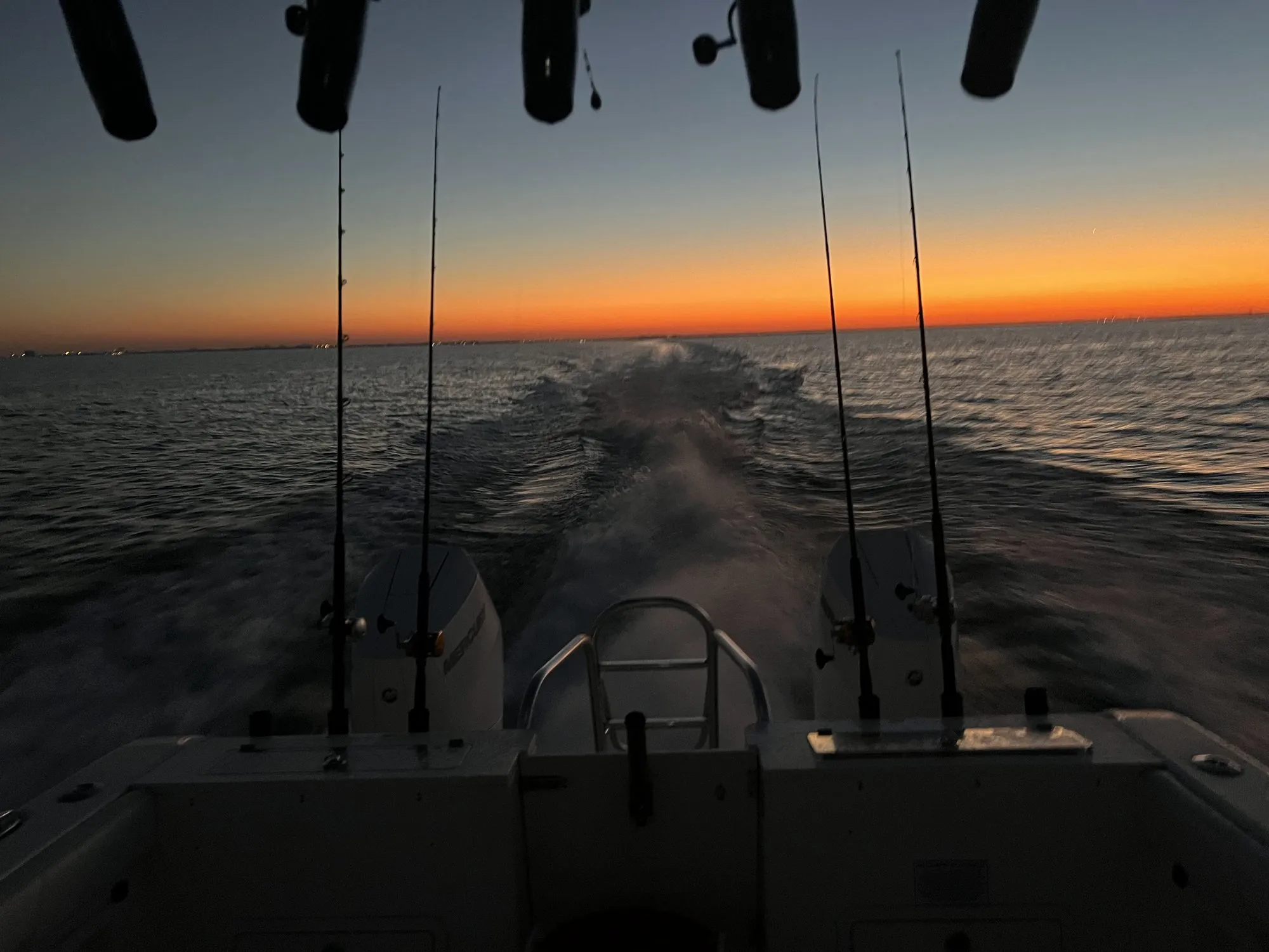 Deep-orange twilight on the horizon past Phat Kat's rods and wake
